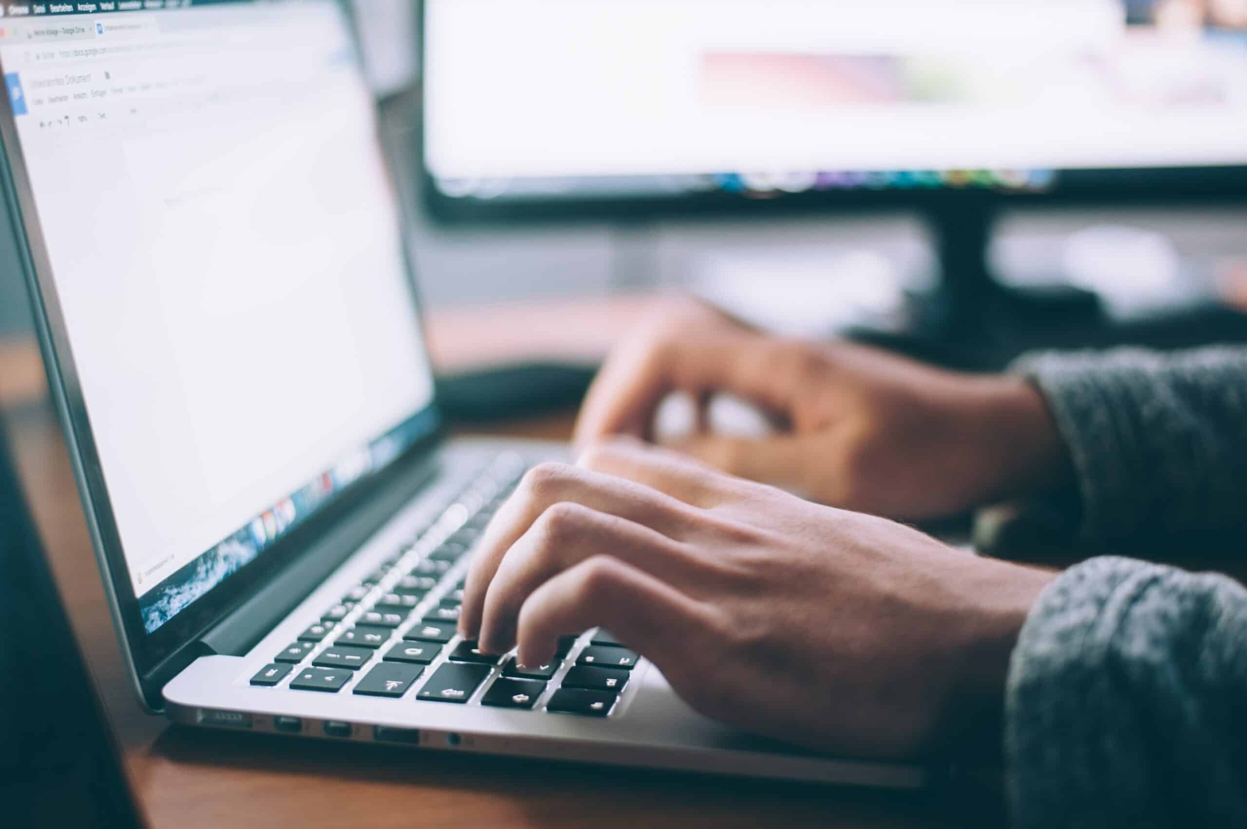 Un commercial de PME consultant une liste de prospects sur un écran, bureau lumineux, ambiance de travail concentrée