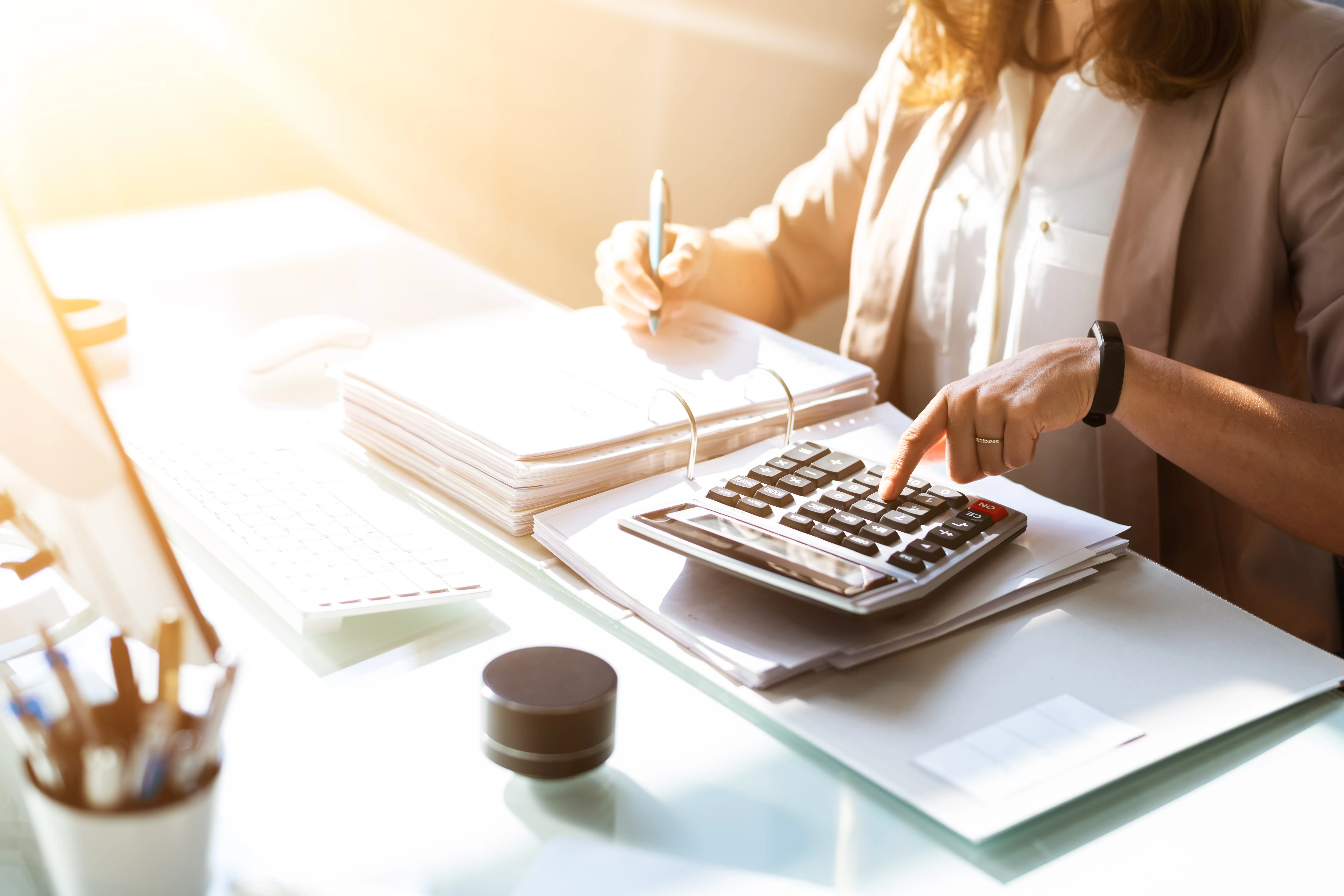 Femme au bureau utilisant une calculatrice.